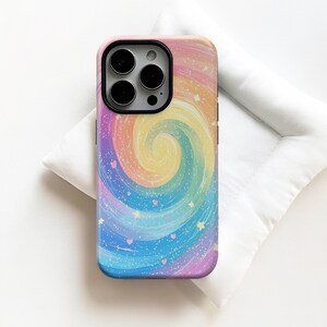 Pode incluir: Uma capa de telefone colorida com um design de redemoinho de arco-íris. A capa apresenta uma espiral de cores pastel, incluindo rosa, amarelo, azul e roxo, com estrelas e corações espalhados. A capa tem um recorte preto para a câmera.
