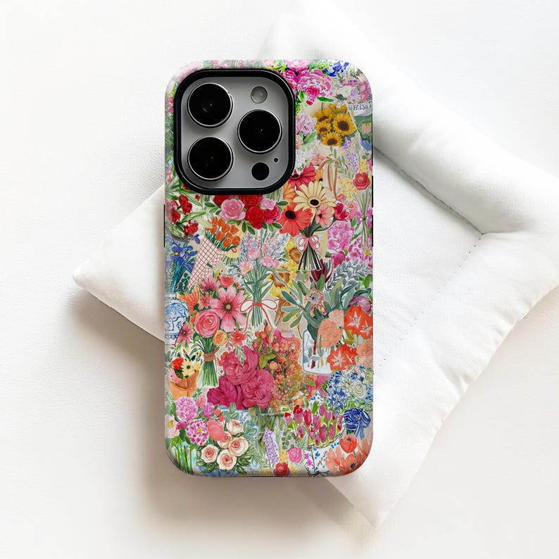 May include: A floral phone case featuring a vibrant collage of colorful flowers, including roses, sunflowers, and daisies. The case has a black camera lens border and is set against a white background.