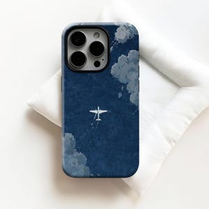 Könnte beinhalten: Handyhülle mit einem dunkelblauen Himmelsdesign, weißen Wolken und einem kleinen weißen Flugzeug. Die Hülle hat einen schwarzen Rand und ein glänzendes Finish. Das Design ist eine Illustration im Aquarellstil.