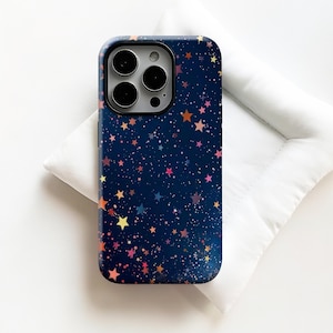 May include: A navy blue phone case with a colorful star pattern. The case features a constellation of small, multi-colored stars in shades of orange, pink, yellow, and purple. The phone case has a camera cutout.