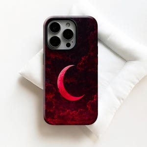 May include: A rectangular smartphone case featuring a dark, deep red and black cloudy night sky background with a prominent, bright red crescent moon centered on the back. The case has a cutout for a triple-lens camera system at the top left corner.