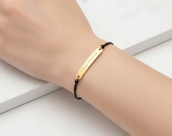 Pulsera grabada, color dorado, con cordón ajustable, ideal para regalar.