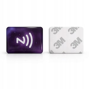 Può includere: Un tag NFC rettangolare viola con un simbolo contactless bianco. Il tag ha un design a galassia. Accanto, un quadrato bianco con la scritta "3M" stampata.