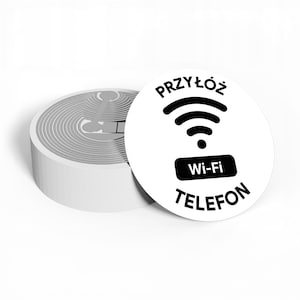 Könnte beinhalten: Weißer und grauer runder Aufkleber mit dem Text "PRZYŁÓŻ TELEFON Wi-Fi" in Schwarz. Der Aufkleber zeigt ein Wi-Fi-Symbol. Der Aufkleber befindet sich neben einem Stapel ähnlicher Aufkleber.