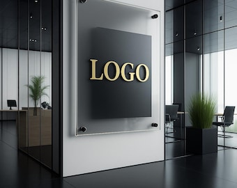 May include: A modern office interior featuring a sign with the word "LOGO" in gold lettering against a black square, mounted on a white wall. The sign is encased in a clear acrylic panel. The space has black flooring and glass walls.
