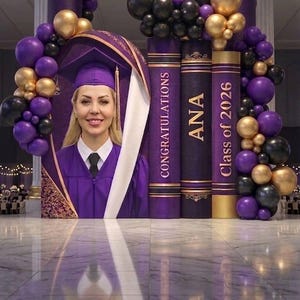 May include: A graduation display featuring a portrait of a graduate in a purple cap and gown, framed by a large arch. Beside the portrait are three tall, cylindrical pillars designed to look like books, labeled CONGRATULATIONS, ANA, and Class of 2026.