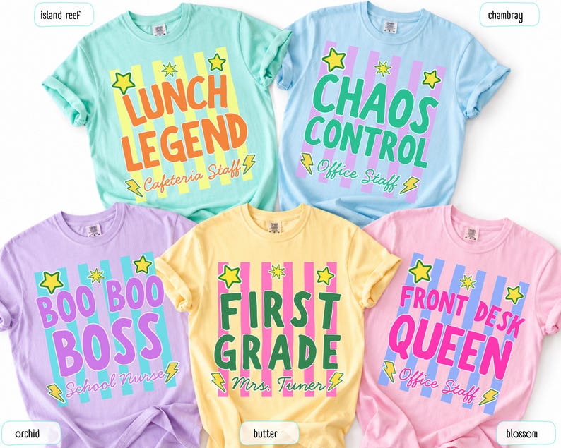 May include: Five short-sleeve t-shirts in island reef, chambray, orchid, butter, and blossom colors. Each shirt features a vertical striped background with yellow stars and lightning bolts, displaying text like LUNCH LEGEND, CHAOS CONTROL, BOO BOO BOSS, FIRST GRADE, and FRONT DESK QUEEN.
