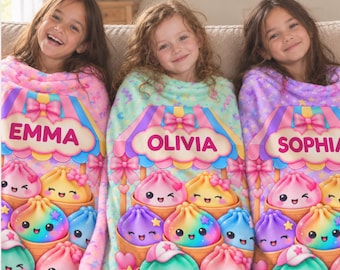 May include: Three soft fleece blankets featuring a colorful carnival stall design with the names EMMA, OLIVIA, and SOPHIA printed in bold letters. Each blanket displays cute, smiling, multi-colored dumpling characters in baskets.