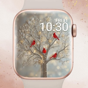 May include: A white smartwatch with a rose gold bezel displays a winter scene. The watch face shows a tree with red cardinals and snowflakes, with the time 10:30 and the date Friday, November 11. The text "In Bloom Babe" is in the upper left corner.