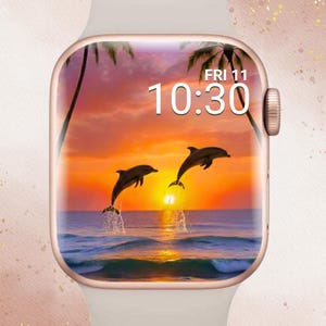 Könnte beinhalten: Eine weiße Smartwatch mit roségoldenem Gehäuse zeigt eine lebendige Sonnenuntergangsszene mit zwei Delfinen, die aus dem Ozean springen. Die Uhrzeit ist 10:30 Uhr am Freitag, mit Palmen vor dem orange-gelben Himmel. Der Text "In Bloom Babe" steht oben.