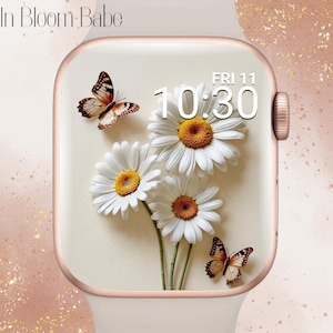 May include: A rose gold smartwatch featuring a floral design. The watch face shows white daisies with yellow centres and two butterflies. The time is 10:30 AM on Friday, the 11th. The text "In Bloom Babe" is at the top.