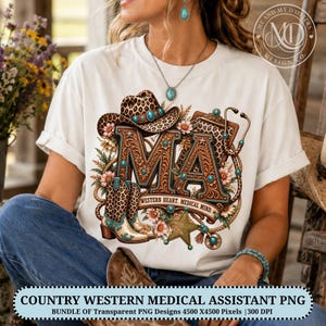 May include: A white t-shirt featuring a graphic design with the letters MA in a brown tooled leather pattern, accented by a leopard print cowboy hat, a stethoscope, a star, and flowers. The text reads WESTERN HEART. MEDICAL MIND.
