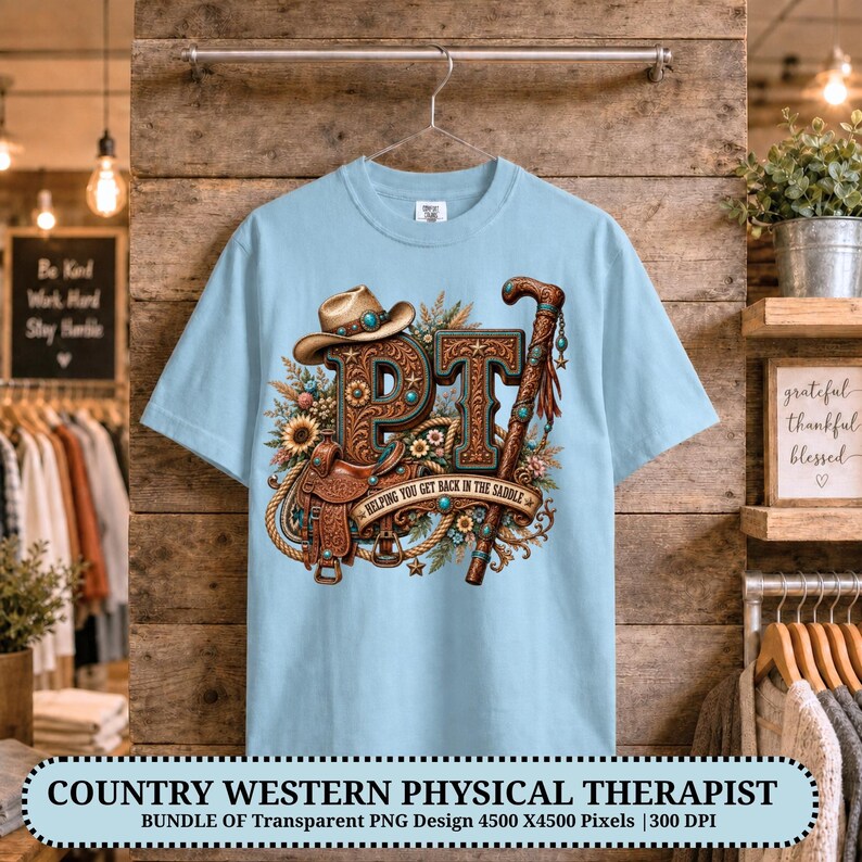 May include: A light blue t-shirt featuring a graphic design with the letters PT, a cowboy hat, a saddle, a cane, and floral elements. The text "HELPING YOU GET BACK IN THE SADDLE" is printed on a banner across the centre of the graphic.