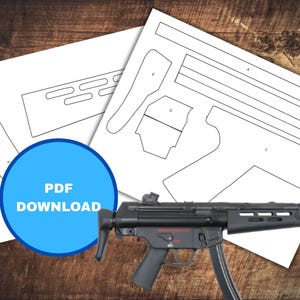 May include: A black and grey firearm with a magazine is displayed on a wooden surface, alongside white paper templates. A blue circle with the text "PDF DOWNLOAD" is in the foreground. The templates appear to be for a model of the firearm.