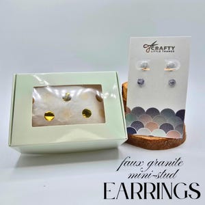 May include: A light green box with a window displaying gold polka dots on white tissue paper. A card displays four faux granite mini-stud earrings. The text on the card reads "Crafty Little Thangs". The text on the bottom reads "faux granite mini-stud EARRINGS".