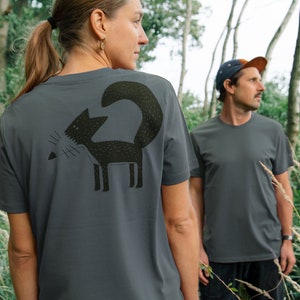 Könnte beinhalten: Zwei Personen tragen graue T-Shirts mit einem schwarzen Fuchs-Motiv auf der Rückseite. Der Fuchs ist stilisiert und hat ein einfaches Design.