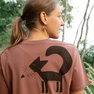 May include: A mauve t-shirt with a black and white illustration of a fox on the back.