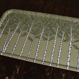 May include: A rectangular serving tray with a green background and a pattern of white birch trees with black outlines. The trees are evenly spaced and have a simple, stylized design.