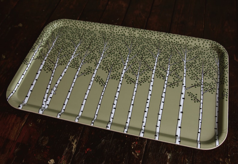 May include: A rectangular serving tray with a green background and a pattern of white birch trees with black outlines. The trees are evenly spaced and have a simple, stylized design.