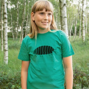 Könnte beinhalten: Ein grünes T-Shirt mit einem schwarzen Motiv einer Kellerassel. Das kurzärmelige Oberteil ist aus einem weichen Stoff gefertigt und für den täglichen Gebrauch geeignet. Das Kellerassel-Motiv ist auf der Vorderseite aufgedruckt.