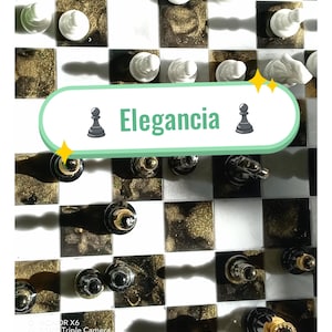 Puede incluir: Juego de ajedrez con un tablero a cuadros blanco y negro y piezas de ajedrez. Los cuadrados del tablero alternan entre blanco y un patrón salpicado de oro. El texto "Elegancia" se muestra en el tablero. El texto "Tablero y fichas" se muestra en la parte inferior.