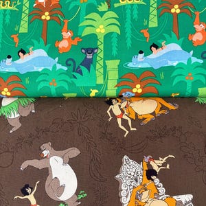 May include: Two fabric panels with jungle-themed illustrations. The top panel is green with cartoon characters, including a tiger, monkey, and panther. The bottom panel is brown with a bear and other characters.
