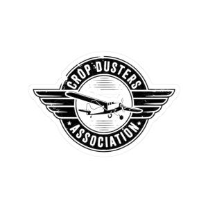May include: A black and white sticker featuring a vintage airplane within a circular emblem. The emblem reads "Crop Dusters Association" in a circular design, with wing-like elements on either side.