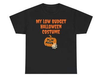 May include: A black short-sleeve t-shirt featuring the orange text MY LOW BUDGET HALLOWEEN COSTUME printed on the chest. Below the text is a graphic of an orange jack-o'-lantern with a grumpy expression and a white spider web attached to its side.