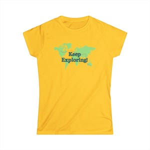May include: A yellow t-shirt featuring a green world map with a dotted line and the text "Keep Exploring!" in teal. The shirt is a solid yellow color and has short sleeves.