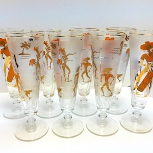 May include: Set of ten frosted glass goblets with gold painted designs of people and palm trees.
