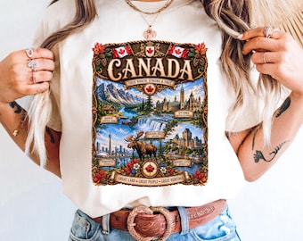 Puede incluir: Una camiseta de color marfil con un estampado gráfico rectangular de Canadá. El diseño incluye el texto "CANADA", "TRUE NORTH, STRONG & FREE" y "GREAT LAND, GREAT PEOPLE, GREAT HERITAGE", junto con ilustraciones de un alce, hojas de arce y monumentos.