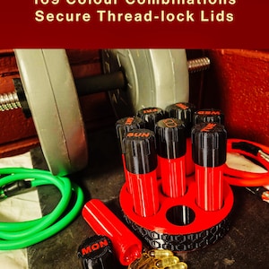 May include: A red and black circular pill organizer with seven vertical compartments labeled with days of the week. The text 169 Colour Combinations Secure Thread-lock Lids is visible. Several yellow gel capsules are scattered near the base.