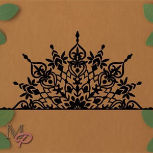 May include: Black, symmetrical, ornamental design with floral and geometric elements. The design is a half-circle shape, with a flat base. The background is a solid, warm brown color, with green leaves in the corners.
