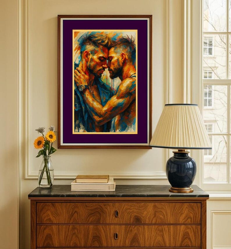 May include: A framed art print showing two men in an embrace, painted in vivid blues, oranges, and yellows. The artwork is a close-up of the figures, highlighting their bond. The frame is brown with a purple mount, adding a touch of elegance to the piece.