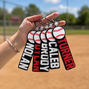 May include: Five rectangular bag tags with a baseball graphic at the top. Each tag features a black border and white background with the names Nolan, Dylan, Brody, Caleb, and Turner printed in bold black or red capital letters on the tags.