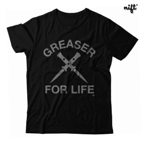 May include: Black t-shirt with a white graphic of two crossed knives and the text "Greaser for Life".