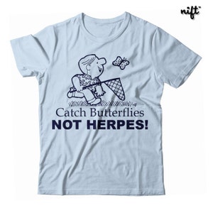 May include: Light blue t-shirt with a cartoon illustration of a person chasing a butterfly with a net. The text "Catch Butterflies NOT HERPES!" is printed in navy blue below the illustration.