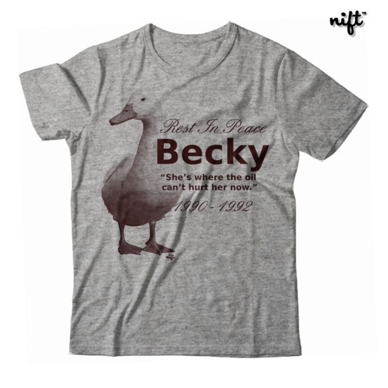 May include: A gray t-shirt with a brown duck illustration and the text "Rest In Peace Becky" "She's where the oil can't hurt her now." 1990-1992.
