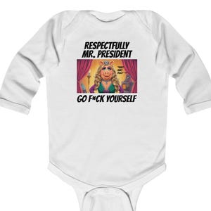 Könnte beinhalten: Weißer Baby-Body mit langen Ärmeln und einer Grafik von Miss Piggy auf der Bühne, mit dem Text "Respectfully Mr. President Go F*ck Yourself". Die Grafik zeigt Miss Piggy in einem grünen Kleid und einer Krone.