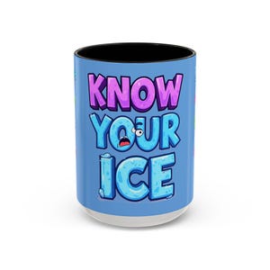 Puede incluir: Taza de cerámica con interior negro y base blanca. La taza presenta la frase "KNOW YOUR ICE" en letras de dibujos animados moradas y azules sobre un fondo azul claro. La taza es cilíndrica.