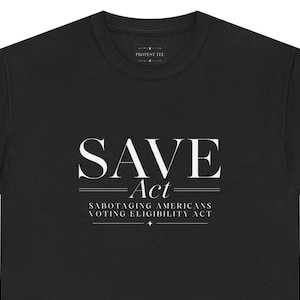 Peut inclure: Un t-shirt noir avec le texte blanc SAVE Act, suivi du sous-titre Sabotaging Americans Voting Eligibility Act, encadré par des lignes horizontales et une petite étoile, avec une étiquette de marque Protest Tee au niveau du col.