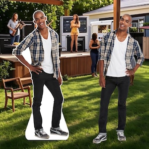 May include: A life-size cardboard cutout of a man wearing a white t-shirt, a blue and tan plaid shirt, black jeans, and gray sneakers. The cutout is posed on a green lawn with a stage and people in the background.
