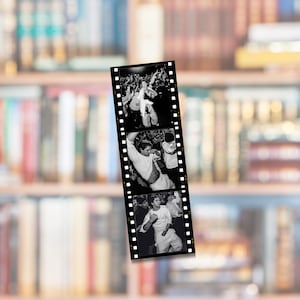 May include: A vertical strip of black and white 35mm film featuring three distinct photographic frames. Each frame captures a person in a white shirt in various poses, with sprocket holes running along both sides of the film strip.