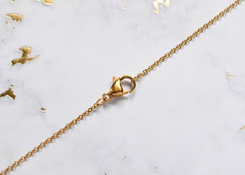 May include: A gold chain necklace with a lobster clasp closure.