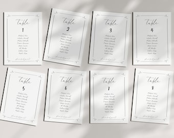May include: Eight white rectangular table seating cards arranged in two rows. Each card features a black border with decorative corner swirls, the word Table followed by a number from 1 to 8, a list of names, and the text please find your seat.