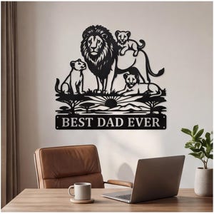 May include: A black metal wall art piece featuring a lion family silhouette with a male lion, two cubs, and a lioness. The design includes a savanna landscape with trees and a sun, with a rectangular plaque at the bottom reading BEST DAD EVER.