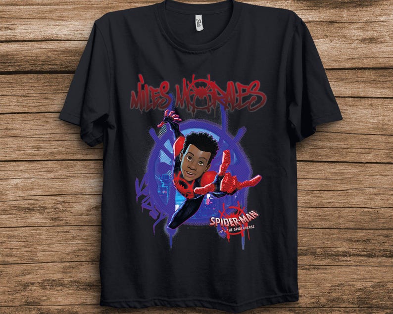 May include: A black short-sleeved t-shirt featuring a graphic of Miles Morales from Spider-Man: Into the Spider-Verse. The design includes red graffiti-style text reading Miles Morales at the top and the movie logo at the bottom right.