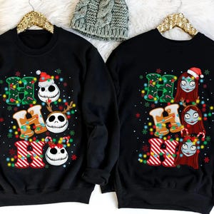 Peut inclure: Sweat-shirts noirs avec l'inscription "HO HO HO" dans une typographie festive. Les lettres "H" sont d&eacute;cor&eacute;es de guirlandes lumineuses et les lettres "O" repr&eacute;sentent Jack Skellington et Sally de L'&Eacute;trange No&euml;l de Monsieur Jack. Th&egrave;me de vacances amusant.