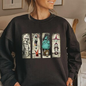 Puede incluir: Sudadera negra con cuatro paneles con personajes de una pel&iacute;cula. Los paneles incluyen a Jack Skellington, Sally, Oogie Boogie y un personaje de bruja. La sudadera es de color oscuro y tiene cuello redondo.