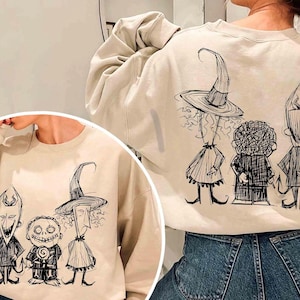 Puede incluir: Sudadera color crema con un boceto en blanco y negro de tres personajes de Pesadilla antes de Navidad. El dise&ntilde;o est&aacute; en la parte delantera y trasera de la sudadera. Los personajes incluyen una bruja, un ni&ntilde;o con una piruleta y un diablo.